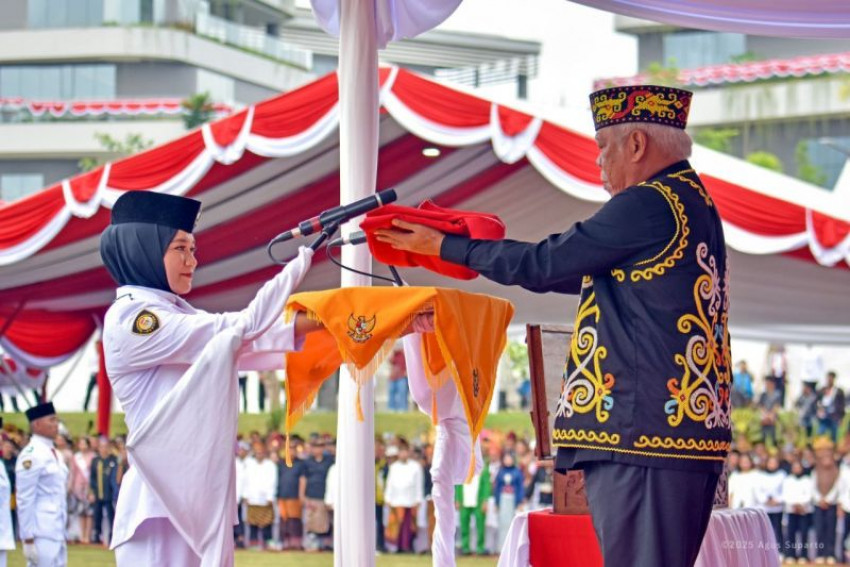 Basuki Hadimuljono, selaku inspektur upacara menyerahkan bendera Merah Putih kepada pembawa baki, Aulia Novita, siswi SMAN 2 Penajam Paser Utara, Kalimantan Timur. ANTARA/ HO-Humas OIKN